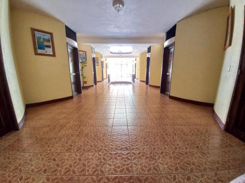 an empty hallway of a building with a tile floor at Hotel Nakbé Atitlán in Panajachel