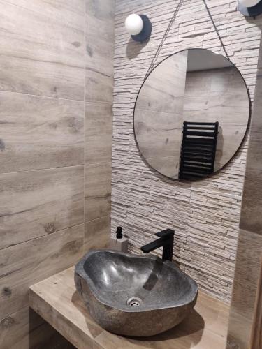 a bathroom with a stone sink and a mirror at Malinowa Chatka in Jankowice
