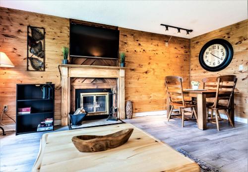 a living room with a fireplace and a clock on the wall at Mountain Villa Magnificent Views - 2 Pools, Fireplace & Hot Tub in Gatlinburg