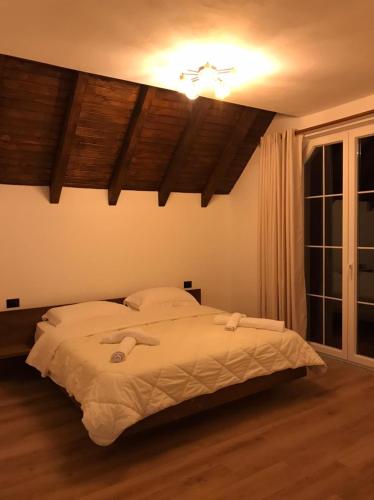 a bedroom with a large bed with a ceiling at Guesthouse Drinos Valbone in Valbonë