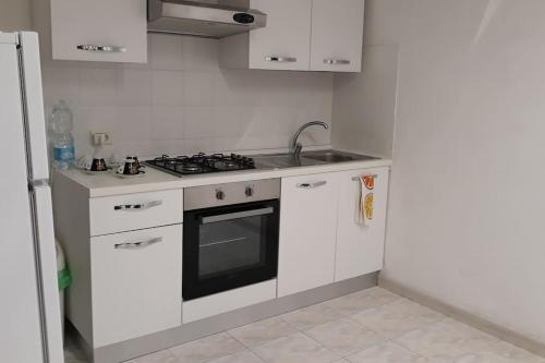 una cucina con armadi bianchi e piano cottura di Appartamento con incantevole panorama: Chieti alta a Chieti