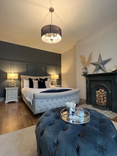 a bedroom with a large bed and a fireplace at Rose Cottage in Morpeth