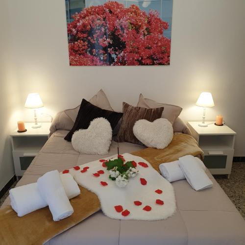 a bed with heart cushions and a painting on the wall at Laverdura in Ubrique