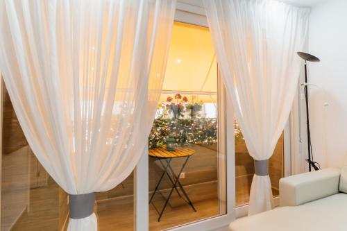 アルメリアにあるTrendy Homes Federico García Lorca - Moderno, céntrico y silenciosoの白いカーテンとクリスマスツリーの部屋