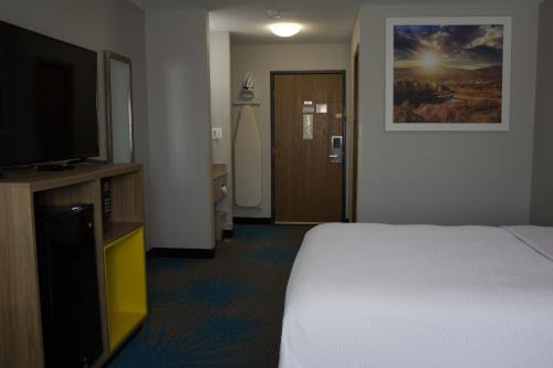 a hotel room with a bed and a television at Days Inn by Wyndham Colby in Colby