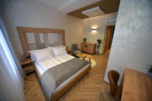 ein Schlafzimmer mit einem großen Bett in einem Zimmer in der Unterkunft Corso Rooms City Centre in Novi Sad