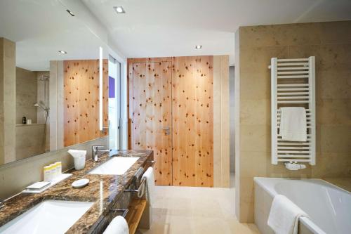 a bathroom with two sinks and a bath tub at Hotel Therme Bad Teinach in Bad Teinach-Zavelstein