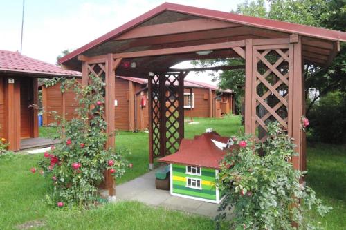 a wooden gazebo with a small house in a yard at Bungalows in Wrzosowo The Bird s Cage for 4 persons in Wrzosowo