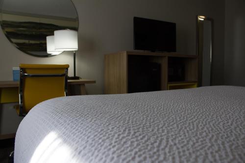 a bedroom with a bed and a flat screen tv at Days Inn by Wyndham Colby in Colby
