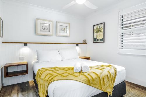 a bedroom with a bed with two towels on it at Beaches Apartments Byron Bay in Byron Bay