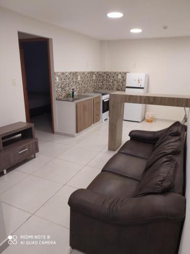 a living room with a couch and a kitchen at Apart cómodo y seguro a pasos de todo 33 in Ciudad del Este