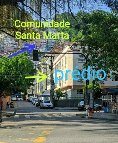 a sign for a street with cars parked on the road at Quitinete ACONCHEGANTE in Rio de Janeiro