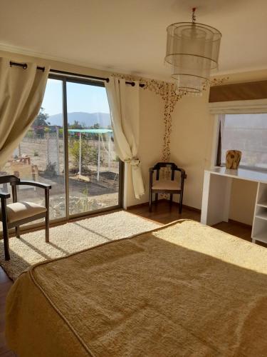 a bedroom with a bed and a large window at Entre tizones y brujos ( cabaña Maggie) in Olmué