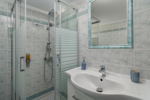 a bathroom with a sink and a glass shower at Vitalis Residences - Rural Living in Péran Triovasálos