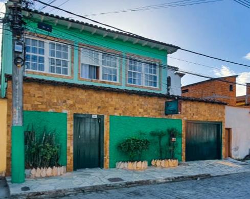 a brick building with a green on a street at Pousada Taquinha Paraty in Paraty