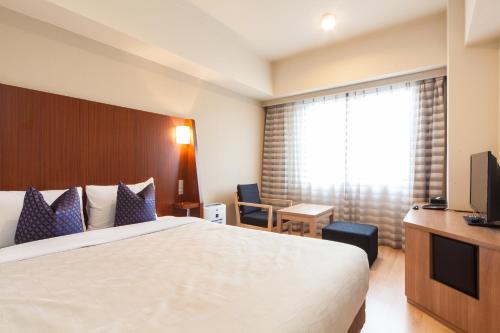 a hotel room with two beds and a television at Sakura Terrace in Kyoto