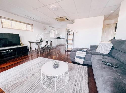 a living room with a couch and a table at Oasis on the Hawkesbury - Water Views in Brooklyn