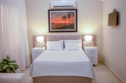 1 dormitorio con 1 cama blanca y 2 mesitas de noche en Acogedor estudio 7 en la Zona Colonial en Santo Domingo