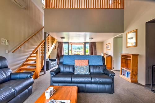 a living room with a leather couch and a table at *** LAKE VILLA 459 *** in Hanmer Springs