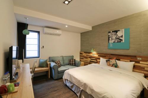 a hotel room with a bed and a couch at Pinestone Inn in Jian