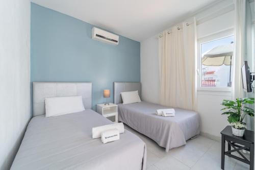 a bedroom with two beds and a window at Lena`s Beach House by HelloVacations in Albufeira