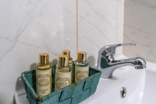 a bathroom sink with three shampoo bottles in a green holder at Lena`s Beach House by HelloVacations in Albufeira