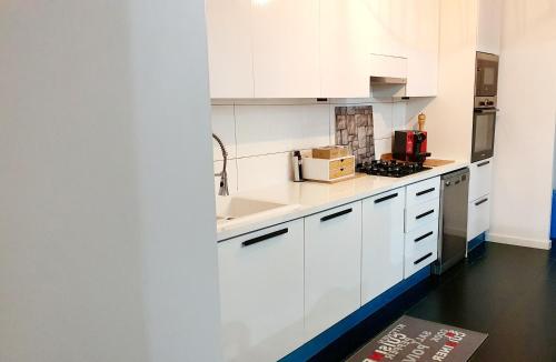 a white kitchen with white cabinets and a sink at Luxe-Design Imperio II- Petit Déjeuner 5min de la Mer in Praia