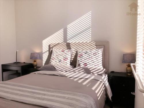 a bedroom with a large bed with striped pillows at Perfect Apt near UCLA w Parking Gym Pool WIFI in Westwood B3 in Los Angeles
