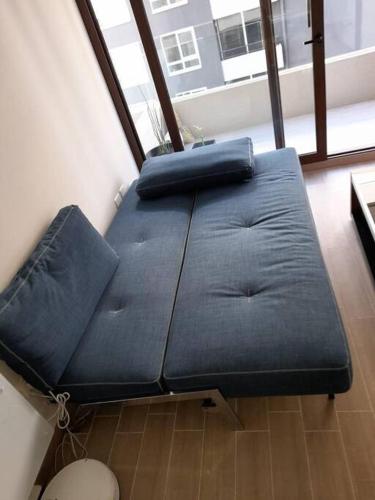 um sofá azul sentado no canto de uma sala em Edifico claro solar piso 16 em Temuco