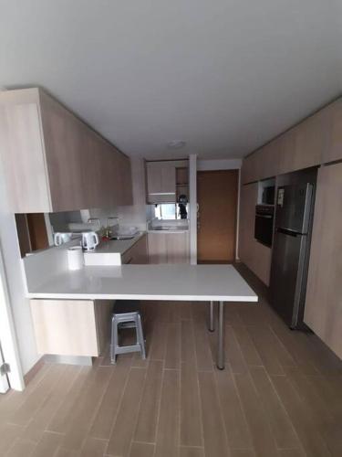 uma cozinha com um grande balcão branco num quarto em Edifico claro solar piso 16 em Temuco