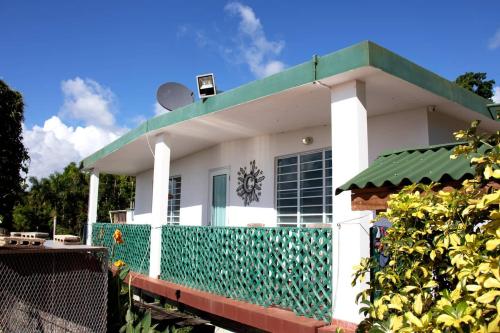 Casa blanca con techo verde en Pancho's Paradise - Rainforest Guesthouse with Pool, Gazebo and View, en Canovanas