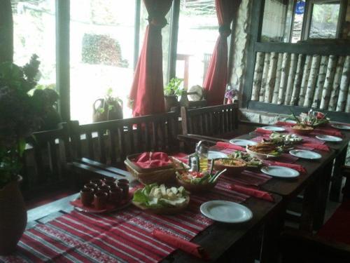 a wooden table with plates of food on it at Pensiunea Casa Dacilor in Podeni