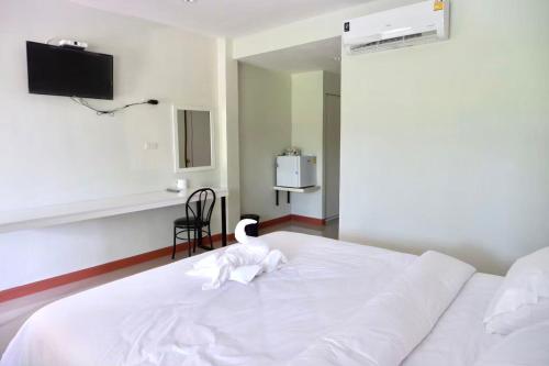 a white bed with a swan sitting on top of it at โรงแรมคอมม่อนเวลธ์ Commonwealth Hotel&Resort in Suan Phung