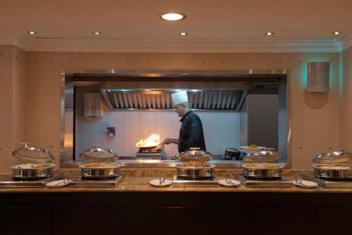 a chef preparing food in a restaurant kitchen at Radisson Blu Martinez Beirut in Beirut