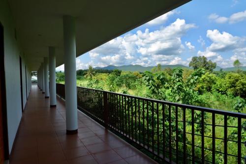 a balcony with a view of the jungle at โรงแรมคอมม่อนเวลธ์ Commonwealth Hotel&Resort in Suan Phung