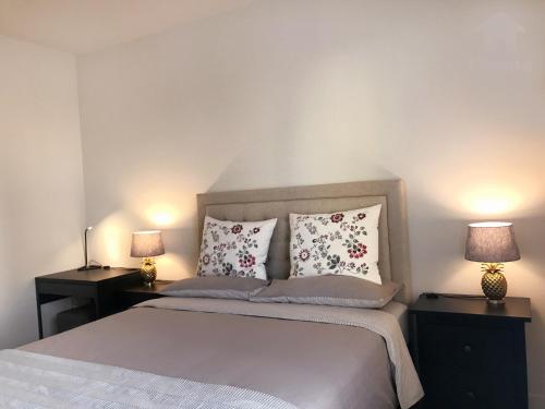 a bedroom with a bed with two lamps on tables at Perfect Apt near UCLA w Parking Gym Pool WIFI in Westwood B3 in Los Angeles