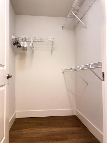 a walk in closet with white walls and wood floors at Perfect Apt near UCLA w Parking Gym Pool WIFI in Westwood B3 in Los Angeles