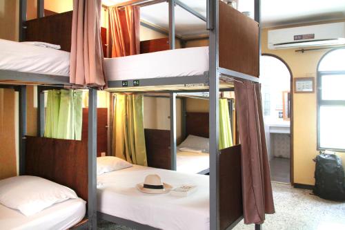 a room with three bunk beds with a hat on it at La Guaca Hostel Santa Marta in Santa Marta