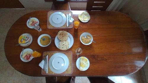 a wooden table with plates of food on it at Nisha homestay inn in Peradeniya