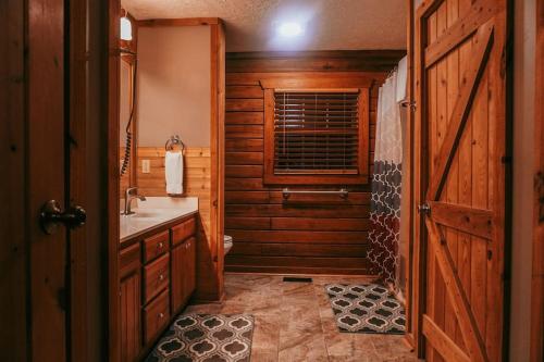 a bathroom with a sink and a wooden door at Mama Bear's Retreat in Sevierville