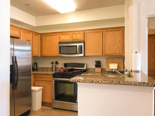 a kitchen with wooden cabinets and stainless steel appliances at Perfect Apt near UCLA w Parking Gym Pool WIFI in Westwood B3 in Los Angeles