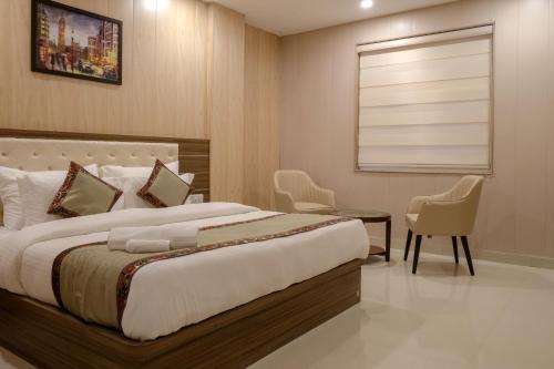a bedroom with a bed and a table and chairs at Hotel Sri Balaji in Varanasi