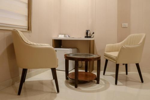 two chairs and a table in a room at Hotel Sri Balaji in Varanasi