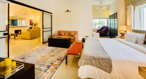 a bedroom with a large bed and a living room at Frangipani Suite in New Delhi