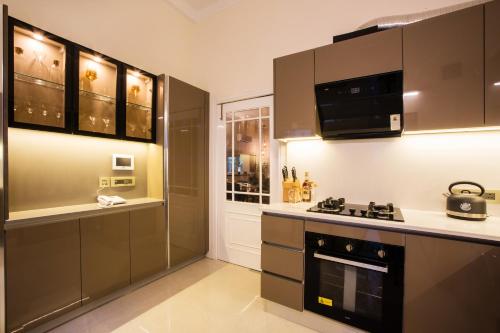 a kitchen with brown cabinets and a stove at Frangipani Suite in New Delhi