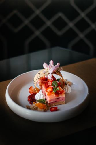 a white plate with a piece of food on a table at Avista Grande Phuket Karon - MGallery in Karon Beach