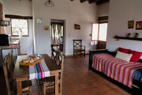 uma sala de estar com uma cama e uma sala de jantar em Pasillos del Viñedo em Cafayate