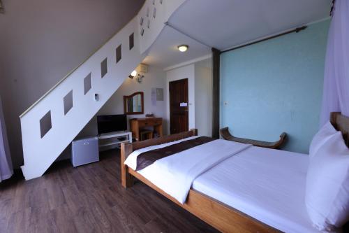 a bedroom with a white bed and a staircase at 近月旭海莊園民宿 in Yanliau