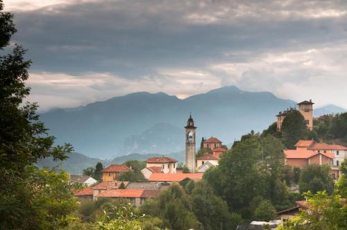 a town with a clock tower and mountains in the background at Casa della Musica in Verbania