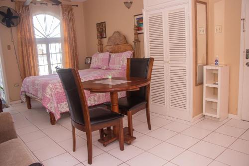 um quarto com uma mesa e cadeiras e uma cama em Elegant Condo Awesome View em Ocho Rios